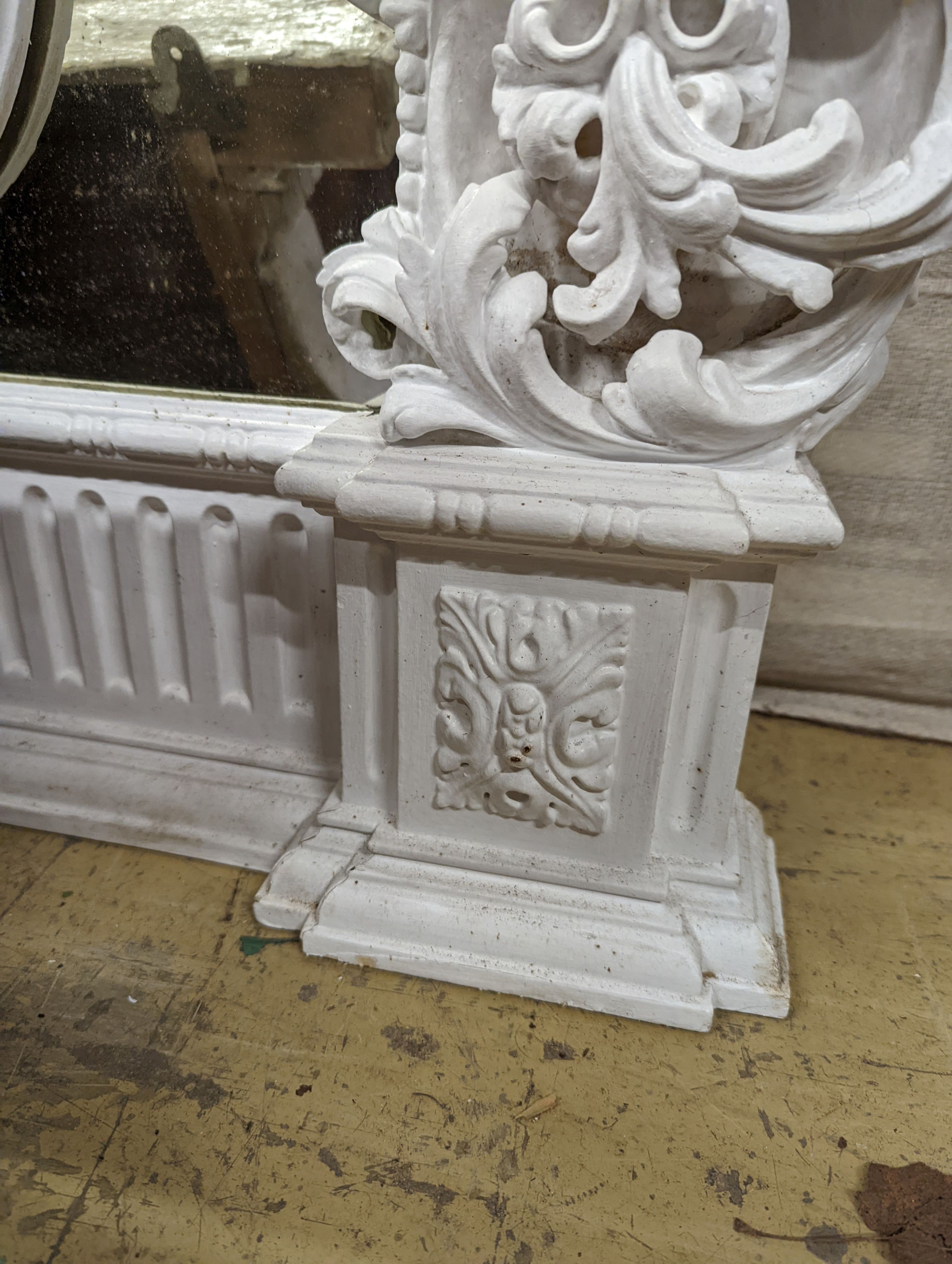 An Edwardian carved wood and gesso overmantel with cherub surmount, later painted white, width 188cm, height 96cm and a two white painted door pediments in need of restoration